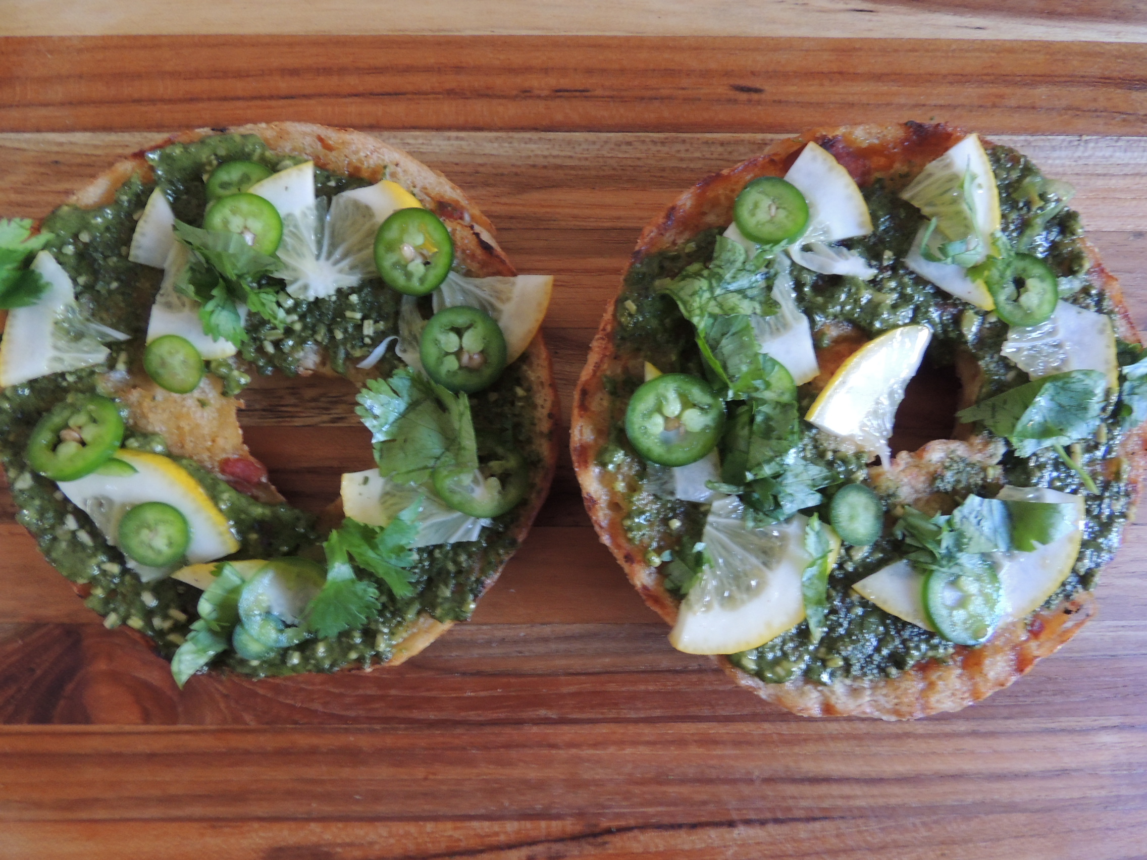 Bagel with lemons, cilantro, basil pesto, and serrano chili