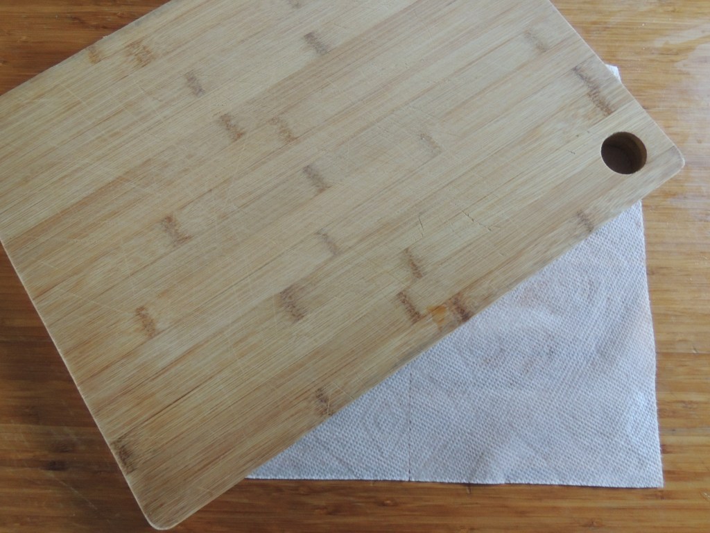 A paper towel under a cutting board.