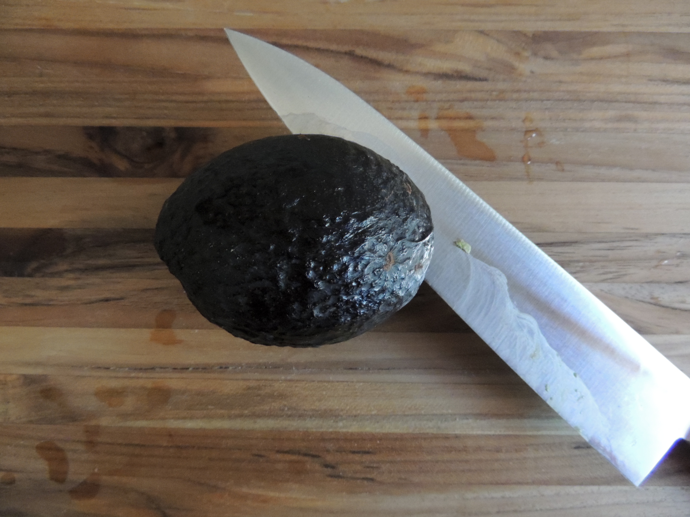 Knife about to slice an avocado